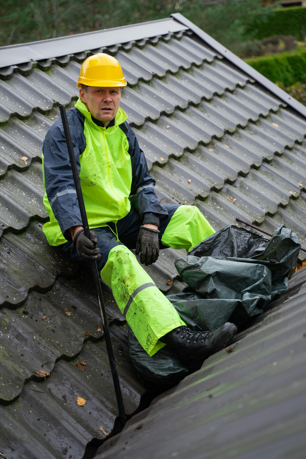 Roofer hammering and repairing damaged section of a roof